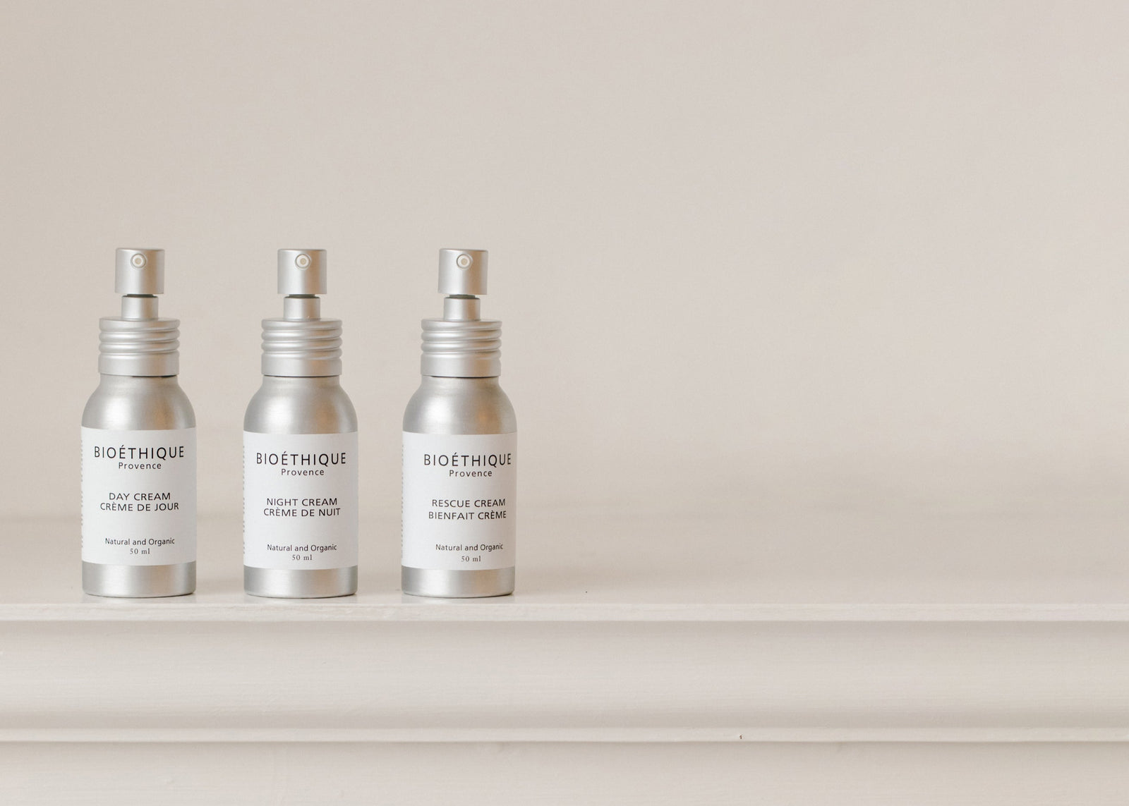 Three Bioethique skincare bottles on a white surface with a neutral background
